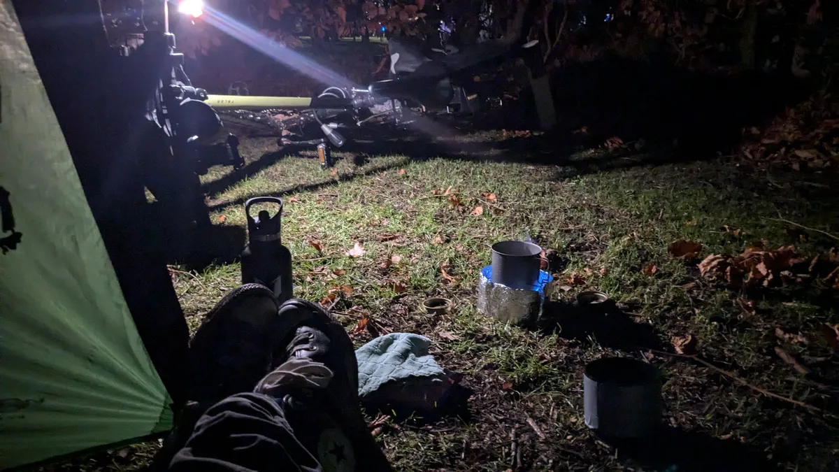 Dark view from tend with bike and light in background